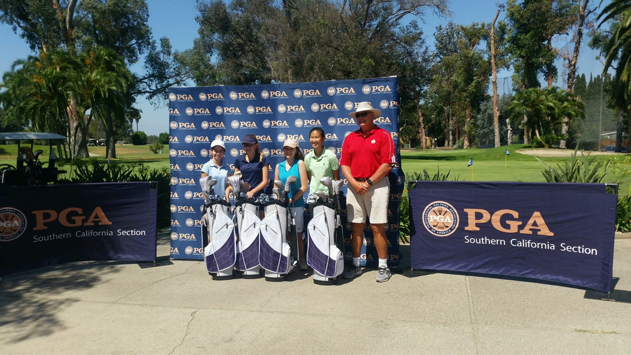 A group of five people stand with golf bags in front of a PGA Southern California Section banner on a sunny day.